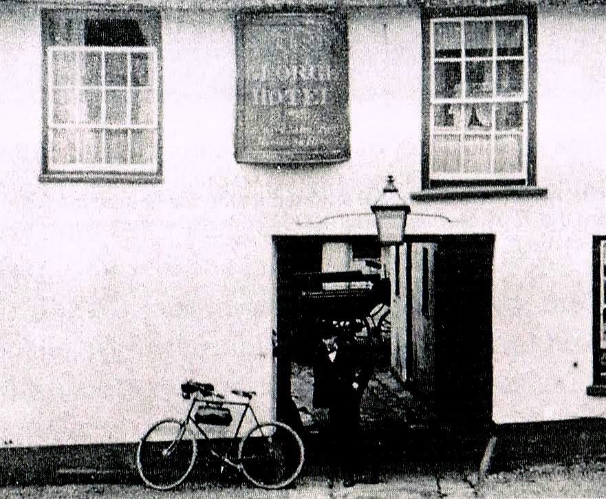 A salesman with his bike outside the George Hotel